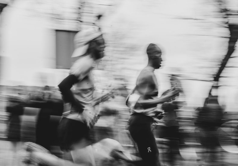 Runners sprint down a street in motion.