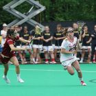 women playing lacrosse game during daytime