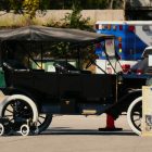 An old fashioned car parked in a parking lot