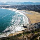 an aerial view of a beach with a city in the background