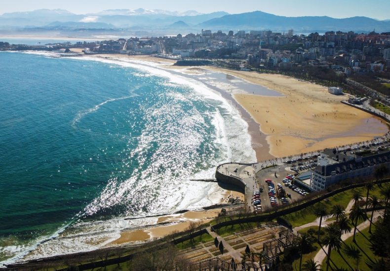 an aerial view of a beach with a city in the background